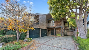 A residential property with a paved driveway, brick pathway, and a garage. - Vacation Home in Seabright (Santa Cruz)