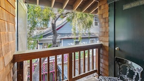 A wooden balcony with a view of a tree and a building. - Vacation Home in Seabright (Santa Cruz)