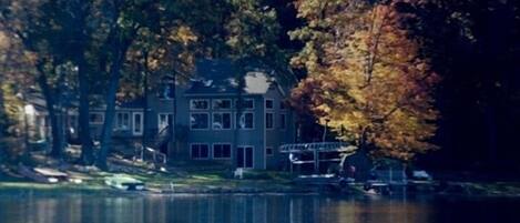 A lakeside house with a dock and boats.