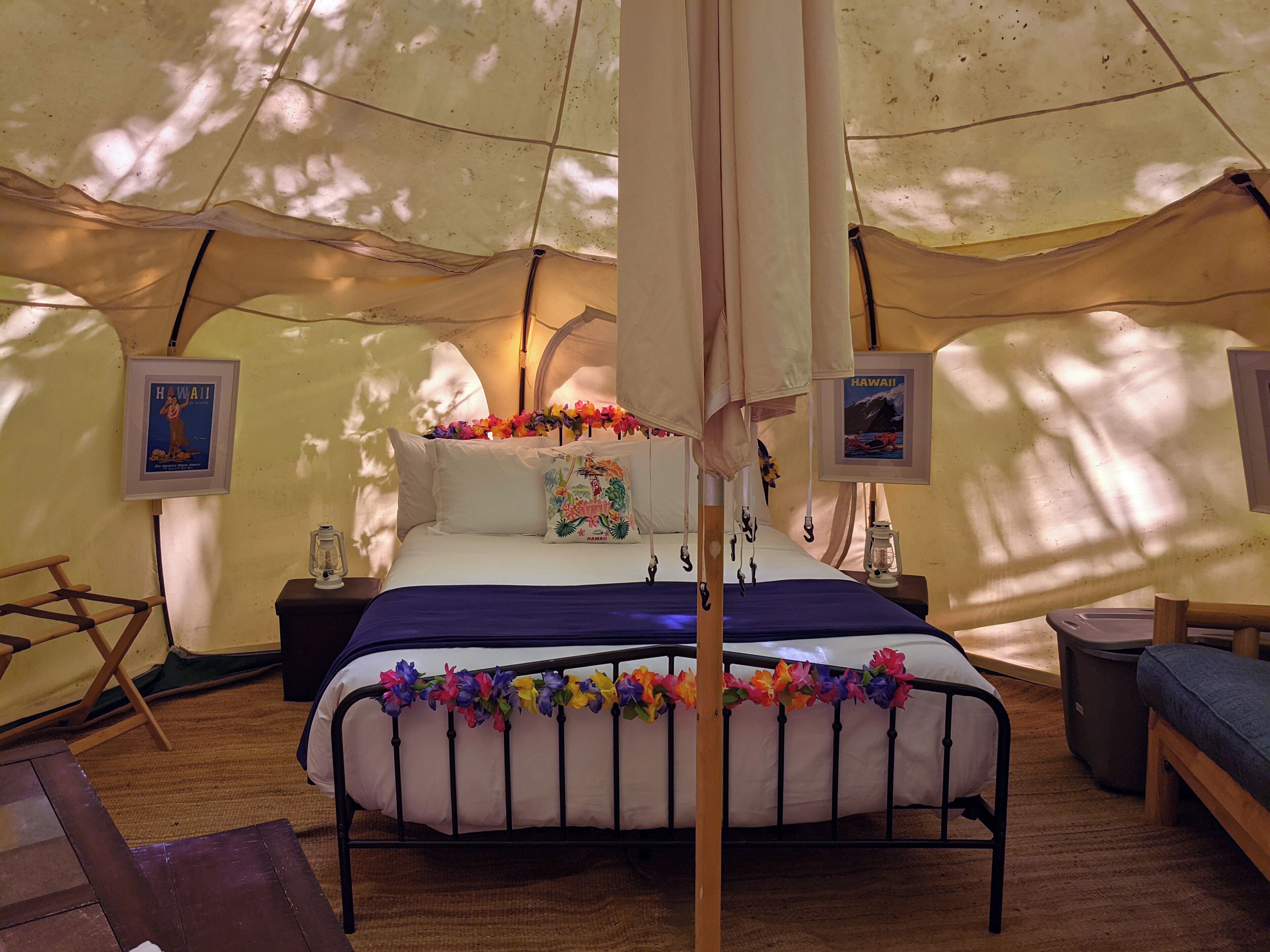 A tented room with a bed, pillows, and a nightstand.
