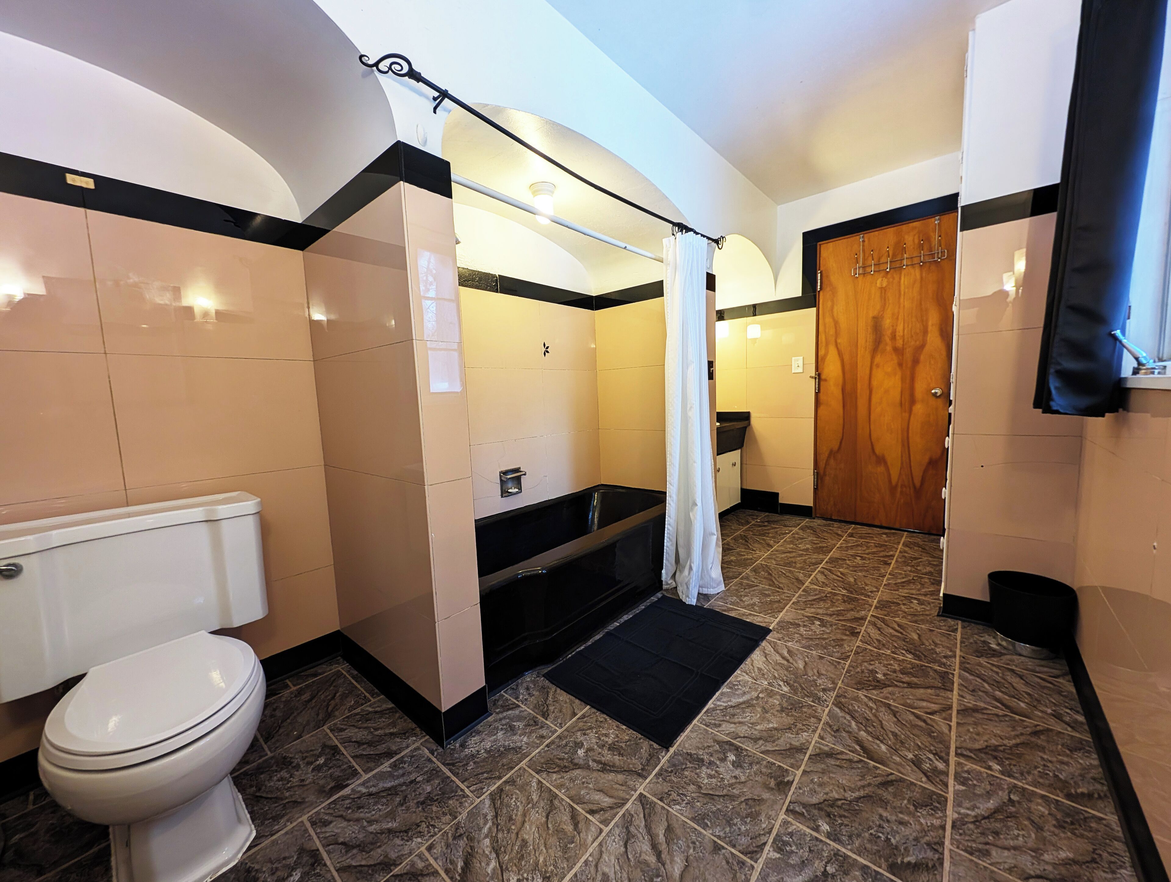 Un baño con inodoro, bañera y cortina de ducha.