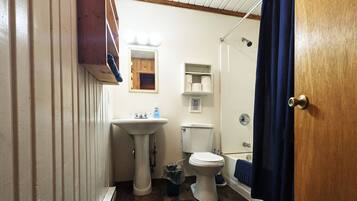 Un baño con lavamanos pedestal, inodoro y bañera.
