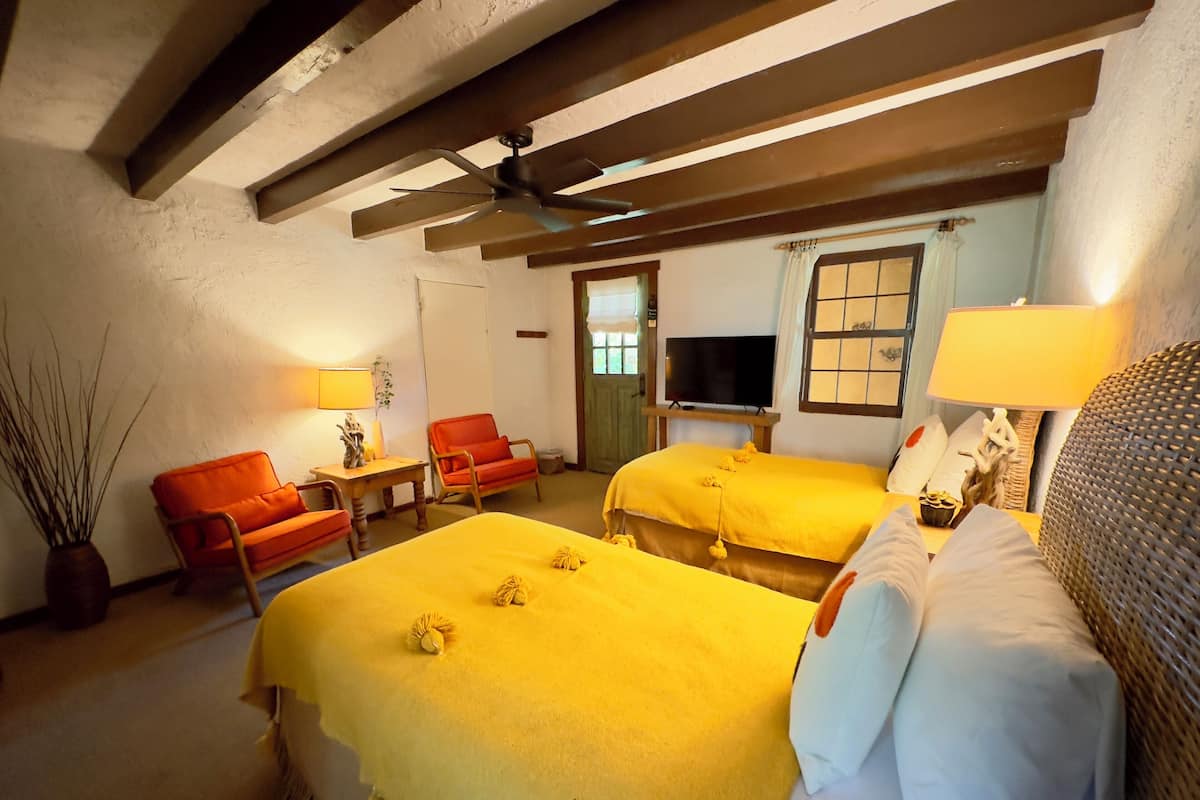 Een hotelkamer met twee bedden, een televisie, een bureau en een stoel.