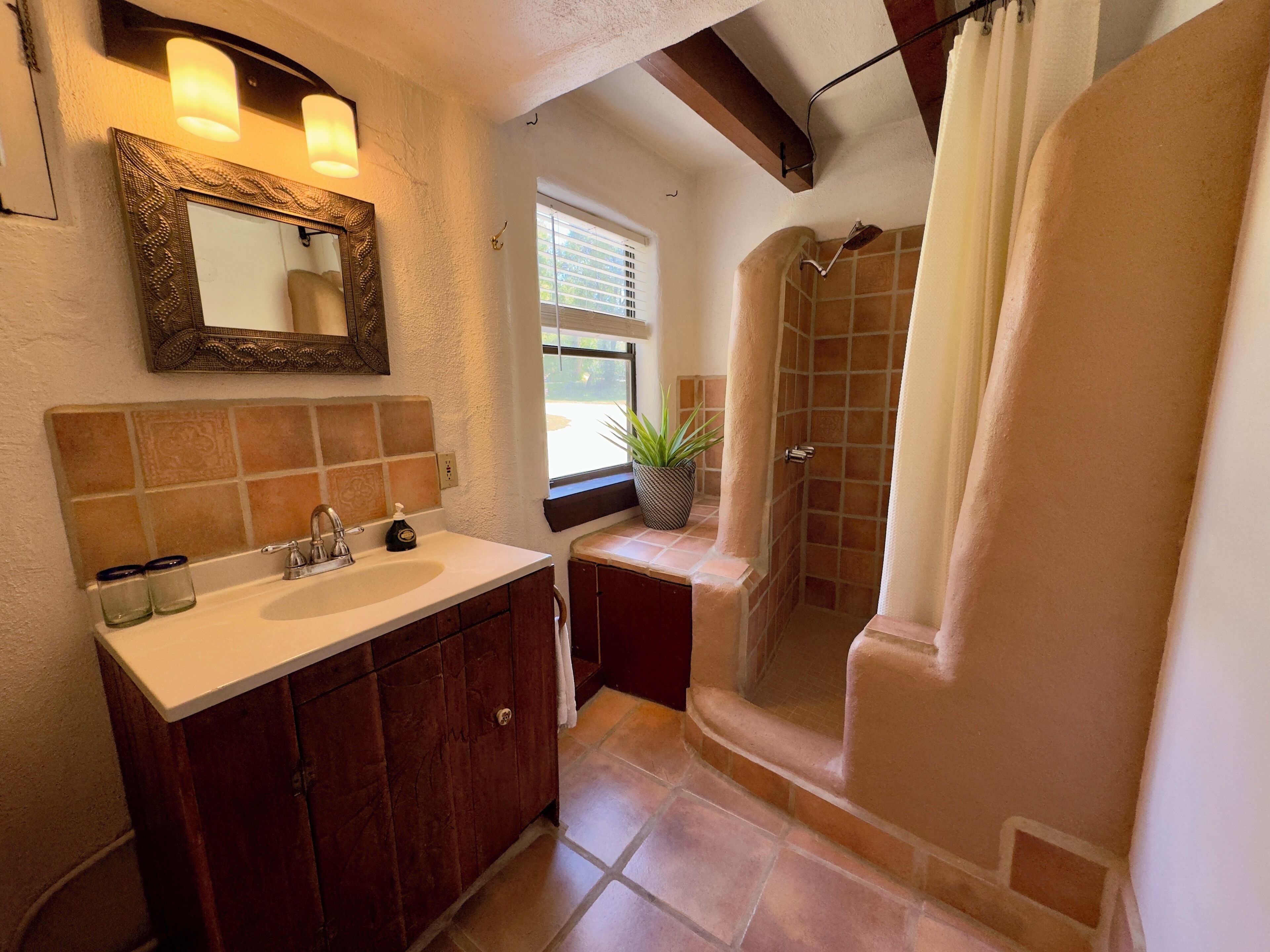Une salle de bain avec un lavabo, un miroir et une douche.