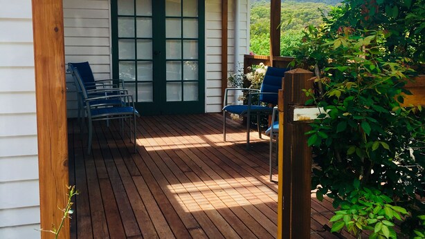 A wooden deck with a pergola, a door with glass panels, and outdoor seating. - White Rose Cottage Healesville (Healesville)