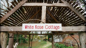 A wooden pergola structure with a sign that reads "White Rose Cottage." - White Rose Cottage Healesville (Healesville)