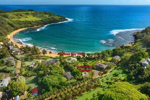 Vista aérea de uma área costeira com praia, campo de golfe e duas propriedades identificadas como 