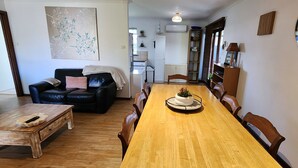 Un coin repas comprenant une table en bois, des chaises, un canapé en cuir noir et une table basse.