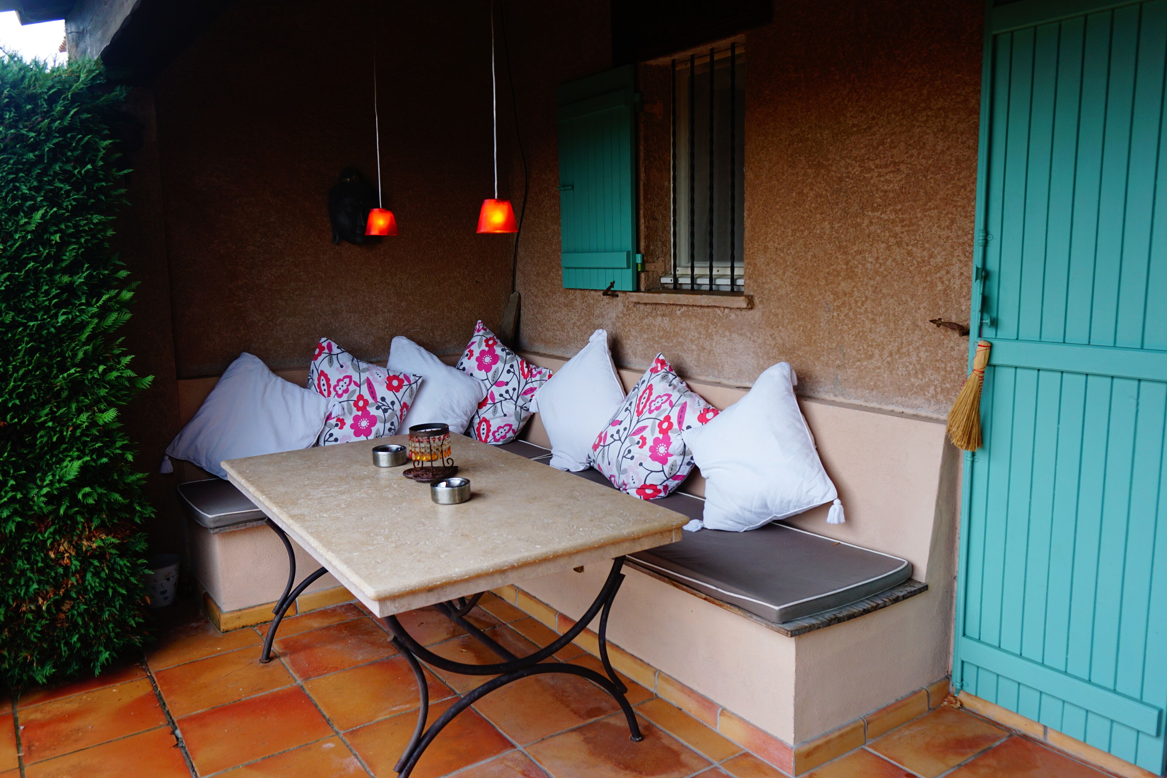 A cozy outdoor seating area with a table, chairs, and a bench.