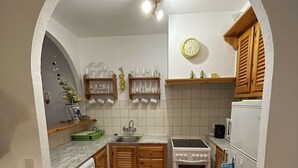 Une cuisine compacte équipée d’un lave-linge, d’une cuisinière et d’un four à micro-ondes.