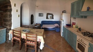 Una cocina acogedora con una mesa de comedor, sillas, un sofá y una estufa.