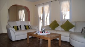 Ein Wohnzimmer mit zwei weißen Sofas, einem Holztisch und einem großen Spiegel.