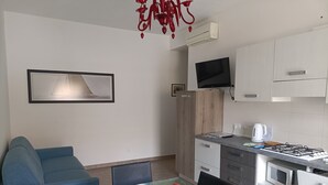 Un espacio moderno para vivir con una mesa de comedor de cristal, sofá azul y faroles rojos.