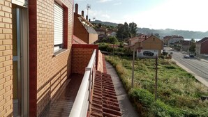 Un immeuble résidentiel à la façade en briques, avec une fenêtre visible et un étroit chemin menant à la rue.