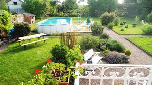 A backyard with a swimming pool, a picnic table, and a garden area.