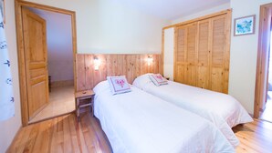 A bedroom with two beds, wooden headboards, and a wooden wardrobe. - VILLA in BRIANCON, south-facing, for a comfortable stay, for 8 to 10 people (Briançon)