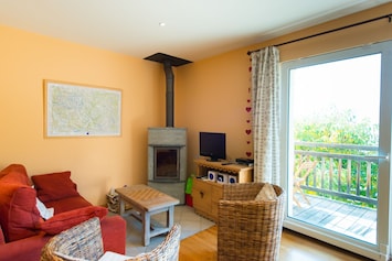 Séjour cosy grande baie vitrée donnant sur balcon terrasse, plein sud