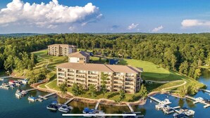 A multi-story hotel with a central courtyard, surrounded by a lake and docked boats. - Lake Front, Walk out ground level, Sunset VIEW, Dedicated Slip, Awesome Pool (Dadeville)