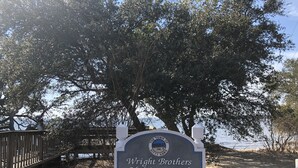 Segnaletica per il sentiero polifunzionale Wright Brothers, finanziato da BDA, con un ponte di legno e alberi sullo sfondo.