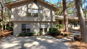 A two-story wooden house with a covered porch and a driveway. - 4th Row Ocean Home w/ Private Pool (Hilton Head Island)