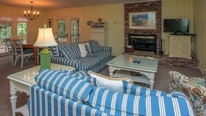 A living room with a sofa set, a coffee table, a television, and a fireplace. - 4th Row Ocean Home w/ Private Pool (Hilton Head Island)
