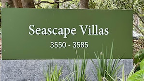 Un letrero verde con el texto 'Seascape Villas 3550 - 3585' que indica un rango de números de calle.
