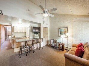 Cozy living space with a kitchenette, flat-screen TV, and comfortable sofa.