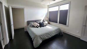 A bedroom with a bed, a ceiling fan, and large windows. - Amazing Location with Private Rooftop (Nashville)