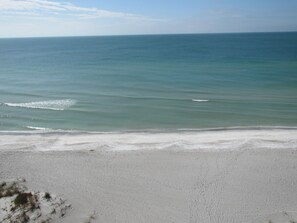 A beach with a sandy shore and calm ocean waves.