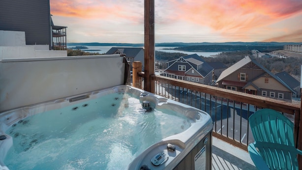 A hot tub on a balcony with a view of a lake and houses in the background. - Table Rock views, Indoor pool, private hot tub (Branson)