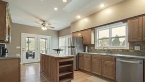 A modern kitchen with wooden cabinets, stainless steel appliances, and a large island. - • Reserve TOQUA COVES • Family Friendly • Lake Access • Two Decks • Sleeps 6+ (Loudon)