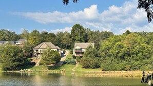A lakeside residential area with houses, a dock, and a clear sky. - • Reserve TOQUA COVES • Family Friendly • Lake Access • Two Decks • Sleeps 6+ (Loudon)