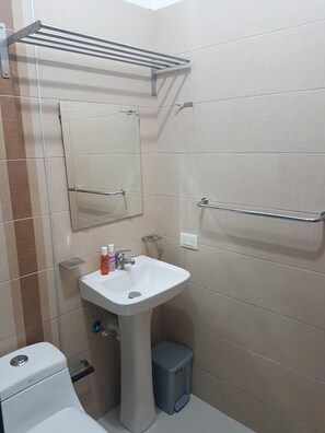 Een bad/douchecombinatie, een haardroger, handdoeken