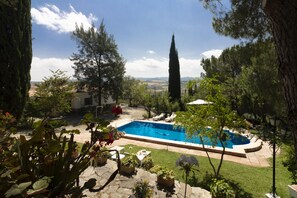 Una piscina al aire libre, sillones reclinables de piscina