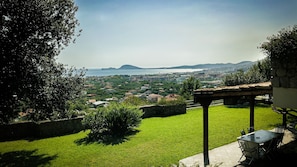 Enjoy al fresco dining or relaxation under a shaded pergola with a scenic view of the coastal town.