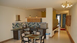 Una cocina moderna con comedor, que incluye un horno empotrado, microondas y salpicadero de azulejos.