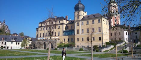 A historic building with a prominent tower, a dome, and a staircase leading to the entrance.