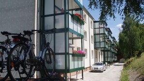 Katu, jonka varrella on rivi rakennuksia, pyörät on pysäköity jalkakäytävälle ja auto on pysäköity kadulle.