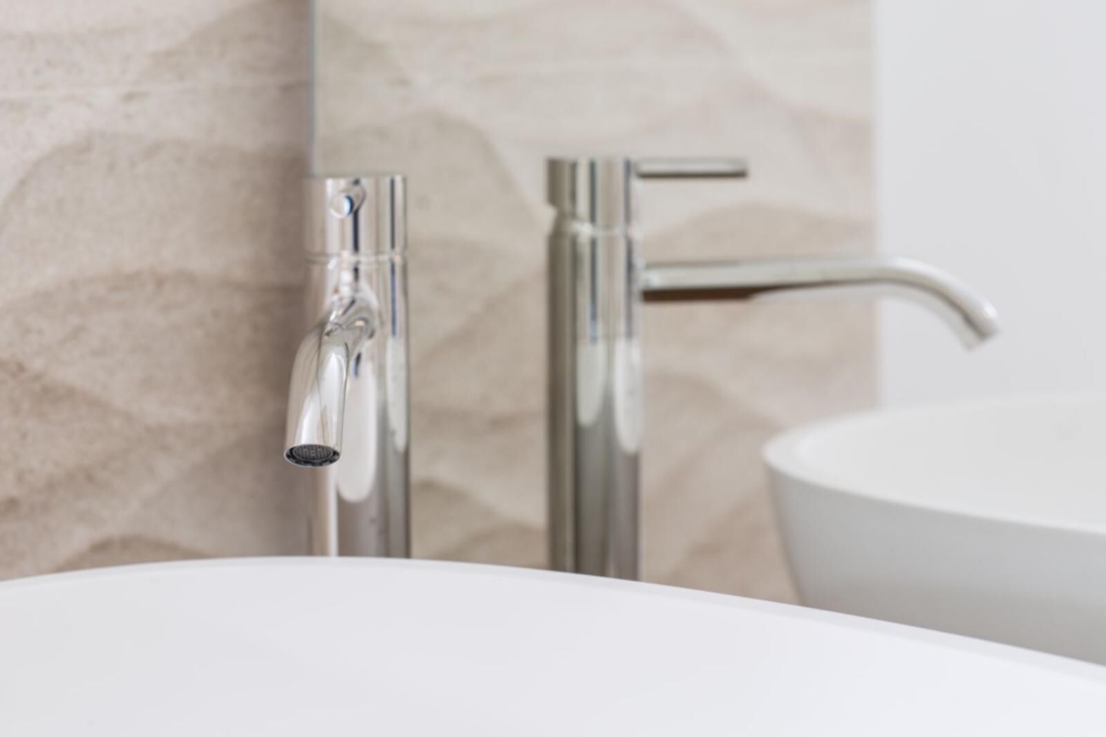 A bathroom with a white sink and chrome fixtures.