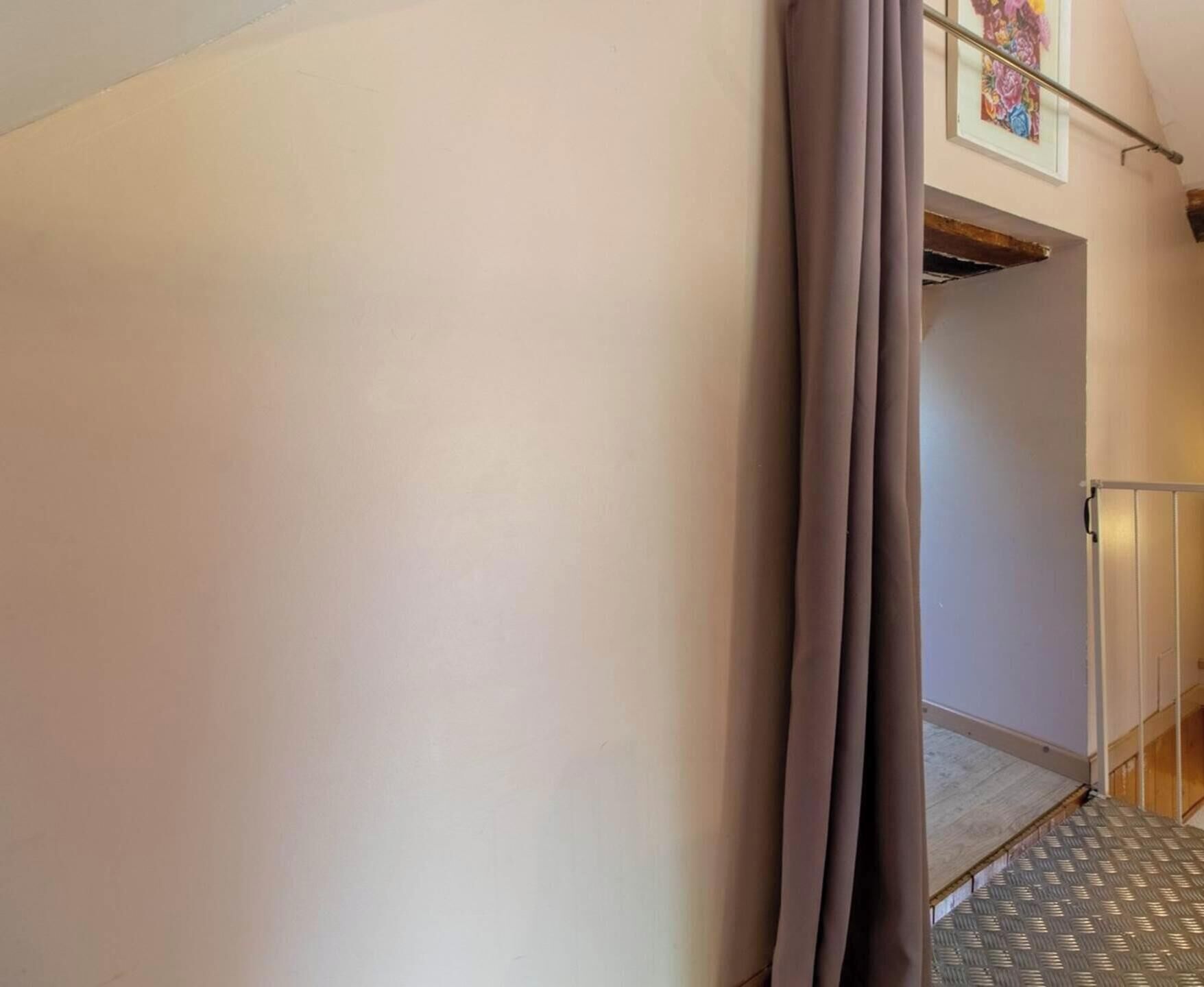 A hallway with a metal staircase, a door, and a wall with a textured pattern.