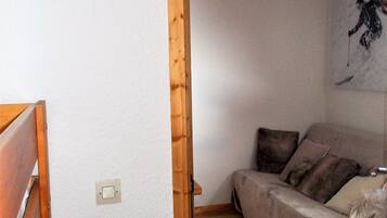 Een kamer met een houten bed, een bank en een kunstwerk aan de muur.
