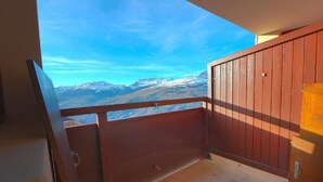 Un balcón con vistas a montañas nevadas bajo un cielo despejado.