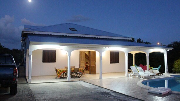 A house with a covered patio, a pool, and a dining area. - LA VILLA DES VOYAGEURS WITH POOL AND SPA FOR 4 TO 12 PEOPLE (SAINT FRANCOIS)