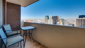 A balcony with a view of a cityscape, featuring a table and chairs. - Furnished 35th Floor Condo In The Heart Of Downtown Denver (Denver)