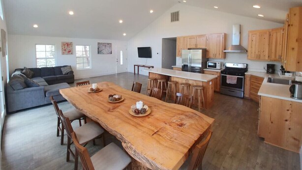 Una cocina amplia con armarios de madera, una mesa de comedor y una isla grande.