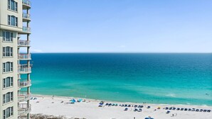 A beachfront hotel with balconies overlooking the ocean, a sandy beach, and clear blue water. - Beach Colony West 15A- 3BD/3BA Gulf front w/Beach Service & Onsite Management (Navarre Beach)