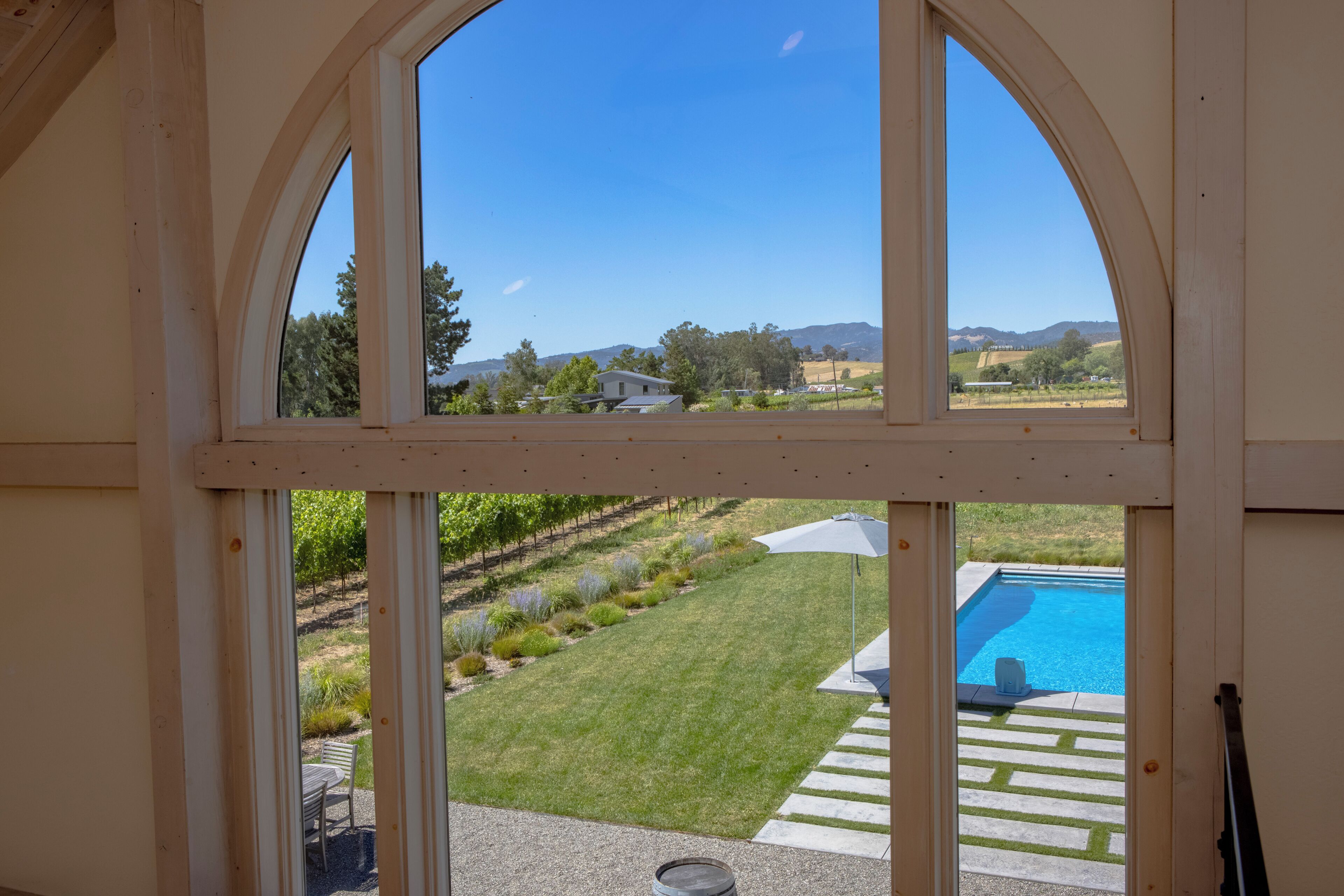 View from loft/greatroom window of Chardonnay block, pool/spa area and mountains