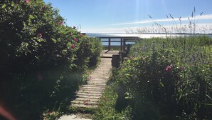 A wooden pathway leading to a wooden deck overlooking a body of water. - Beautiful, private oceanfront cottage on the Bay of Fundy (Port Williams)