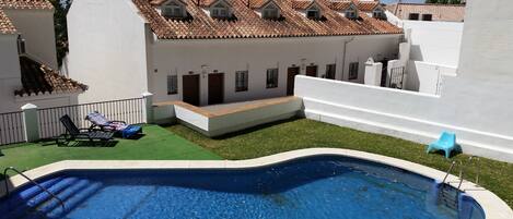 Een buitenzwembad en ligstoelen