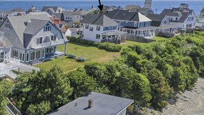 A coastal residential area with houses, a lighthouse, and a view of the ocean. - HAMPTON BEACH OCEANFRONT HOME SITUATED ON GREAT BOARS HEAD (Hampton)
